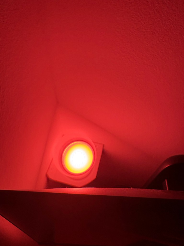 Printed fixture with a round LED, lighting a wall red
